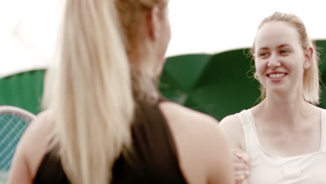 Caucasian-female-tennis-players-handshaking-at-the-tennis-court-after-match-or-practice.-4K-UHD-RAW-graded-footage